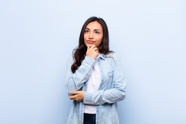 jeune femme brune douteuse et confuse avec différentes options se demandant quelle décision prendre