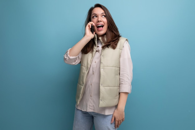 jeune femme brune énergique dans des vêtements décontractés parlant au téléphone portable