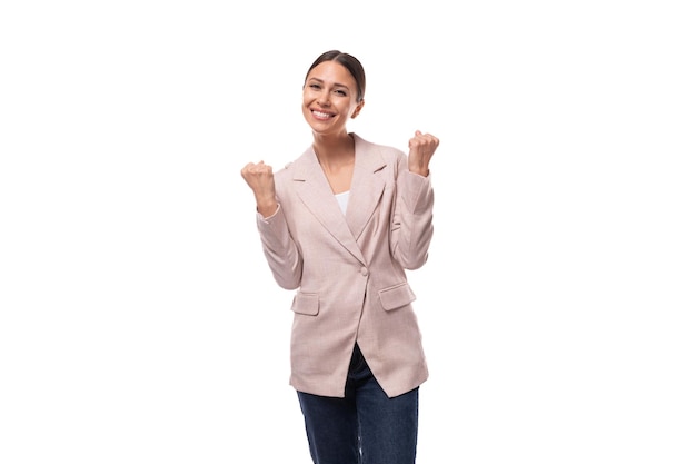 Jeune femme brune européenne souriante et joyeuse, vêtue d'une élégante veste beige