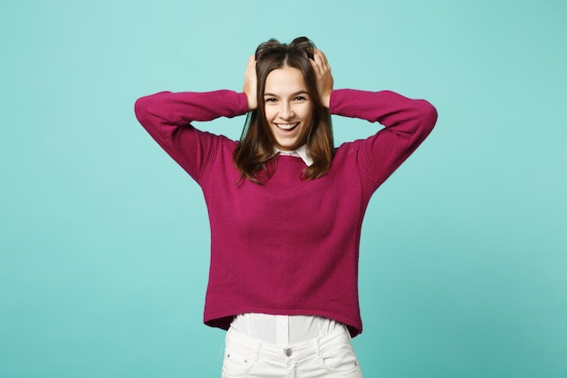 Jeune femme brune fille dans des vêtements décontractés posant isolé sur bleu vert turquoise mur fond studio portrait. Concept de mode de vie des émotions sincères des gens. Maquette de l'espace de copie. Regarder le sourire de la caméra