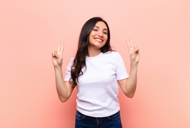 jeune femme brune gesticulant victoire ou paix avec les deux mains