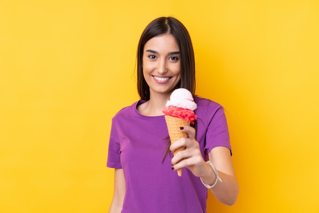 Jeune femme brune avec une glace au cornet avec une expression heureuse