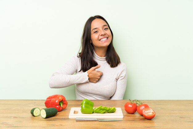 Jeune femme brune avec des légumes donnant un geste du pouce