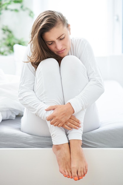 Jeune femme brune malade au lit