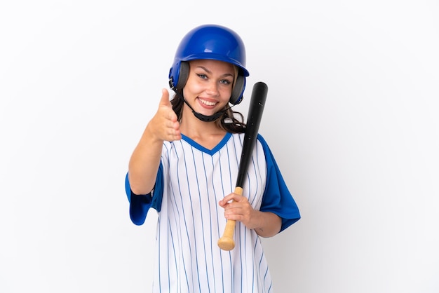 Jeune femme brune en peignoir se brosser les dents sur fond bleu isolé avec une expression heureuse