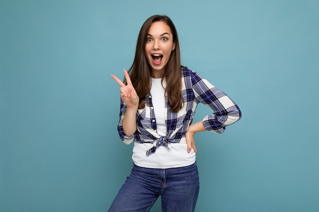 Jeune femme brune positive heureuse surprise belle winsom avec des émotions sincères portant un chèque