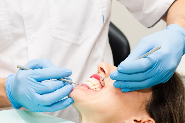 Une jeune femme brune rend visite au dentiste.