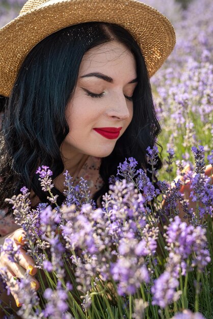 Jeune femme brune séduisante au chapeau entouré de fleurs de lavande