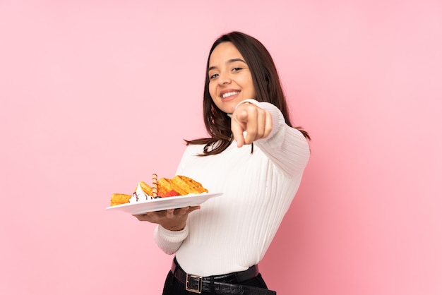 Jeune femme brune tenant des gaufres isolées