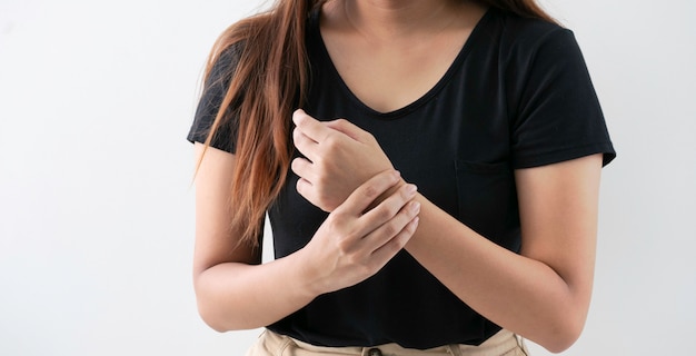 Jeune femme de bureau souffrant de douleur à la main sur fond blanc.