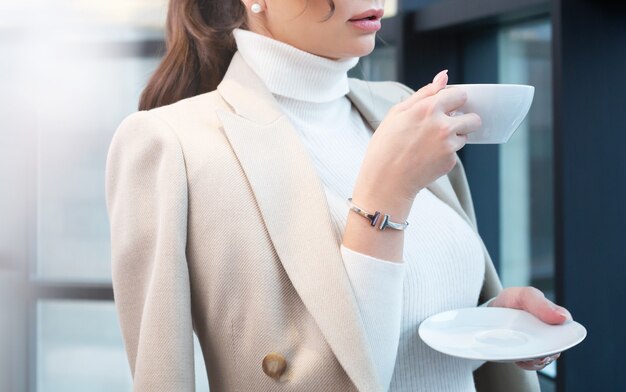 Jeune femme buvant le café du matin près de la fenêtre