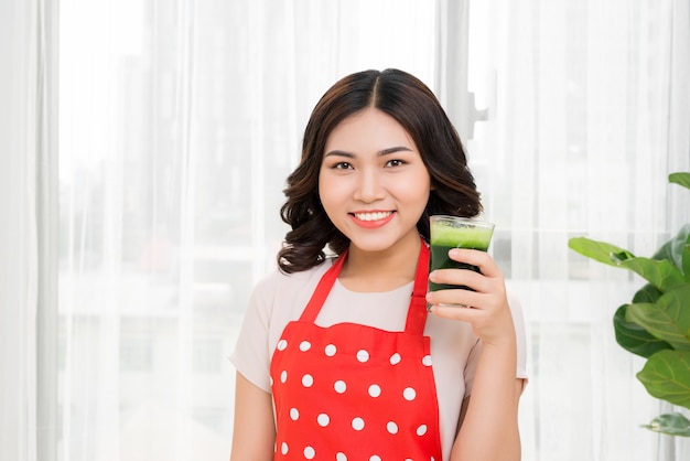 Jeune femme buvant un cocktail vert