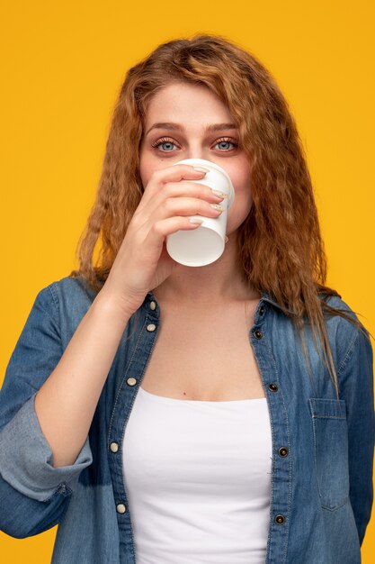 Jeune femme buvant du café à emporter