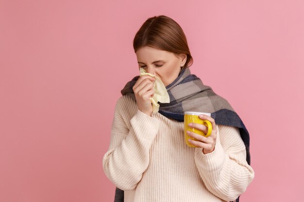 Photo une jeune femme buvant du café sur un fond rose.