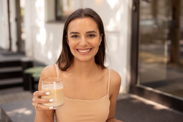 Photo jeune femme buvant du café glacé