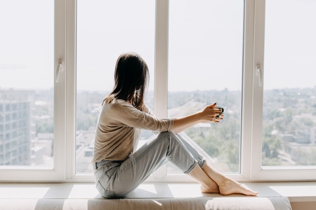 Jeune femme buvant du café à la maison