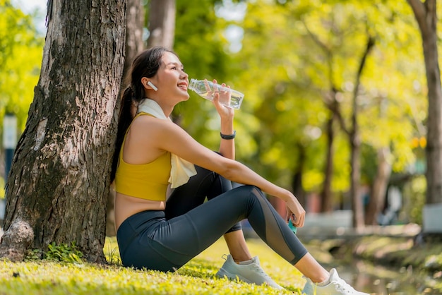 Jeune femme buvant de l'eau à partir d'une bouteille femme asiatique buvant de l'eau après des exercices ou du sport