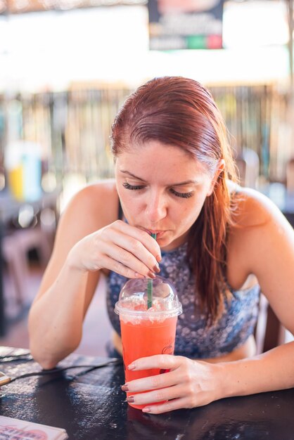 Photo une jeune femme buvant un verre sur la table.