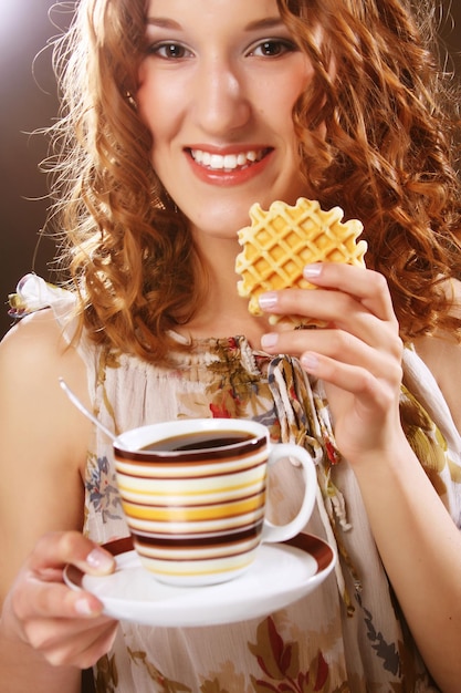 Jeune femme avec café et biscuits