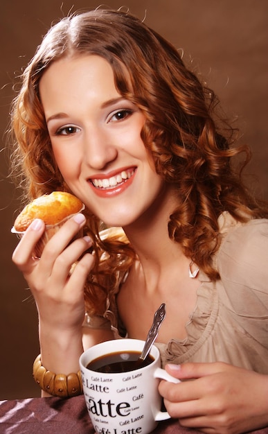 Jeune femme avec café et gateau