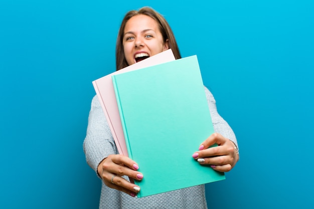 Jeune femme avec un cahier contre bleu