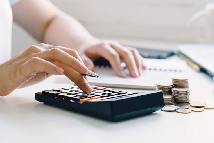 Photo jeune femme calculant les dépenses mensuelles à la maison, les taxes, le solde du compte bancaire et le paiement des factures de carte de crédit.