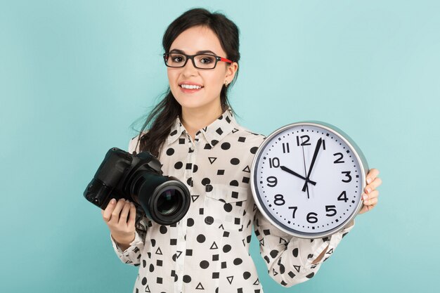 Jeune femme avec caméra et horloges