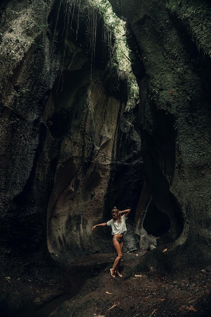 Jeune femme à la cascade dans la roche Bali Indonésie