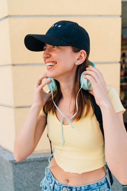 Jeune femme avec un casque à la menthe et une casquette noire à l'extérieur dans la rue