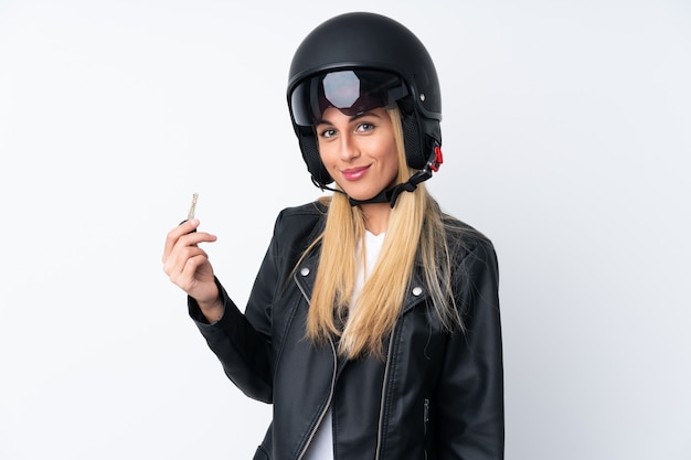 Jeune femme avec un casque de moto sur un mur blanc isolé