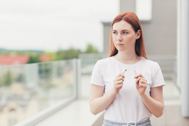 Une jeune femme casse une cigarette comme signe qu'elle a arrêté de fumer