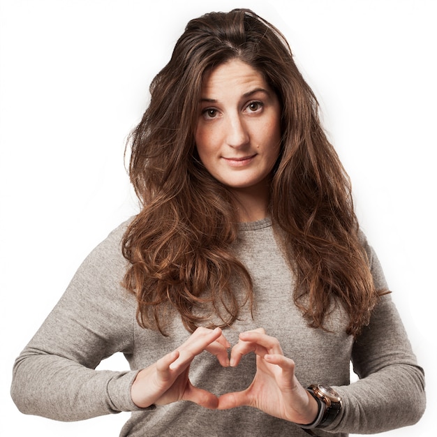 Jeune femme casual avec un geste du coeur sur la poitrine