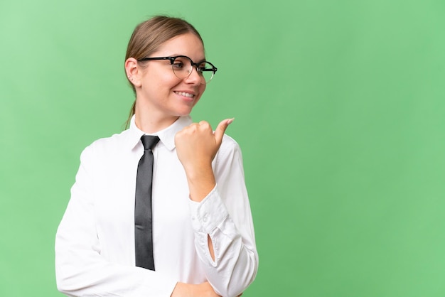 Jeune femme caucasienne d'affaires sur fond isolé pointant vers le côté pour présenter un produit