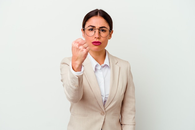 Jeune femme caucasienne d'affaires isolée sur fond blanc montrant le poing à la caméra, expression faciale agressive.