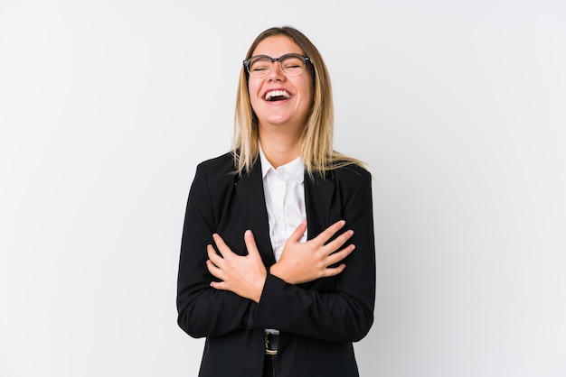 Jeune femme caucasienne d'affaires rit joyeusement et s'amuse à garder les mains sur le ventre.