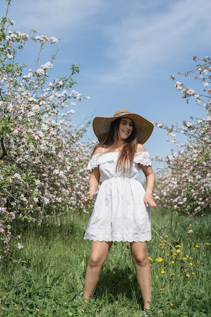 Jeune femme caucasienne appréciant la floraison d'un pommier