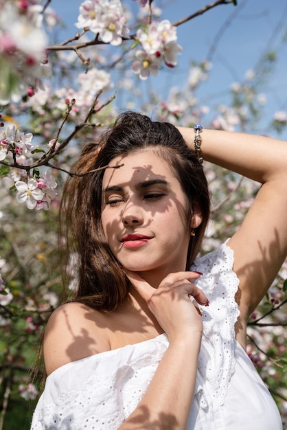 Jeune femme caucasienne appréciant la floraison d'un pommier