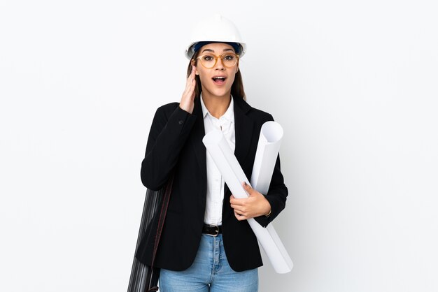 Jeune femme caucasienne architecte avec casque et tenant des plans