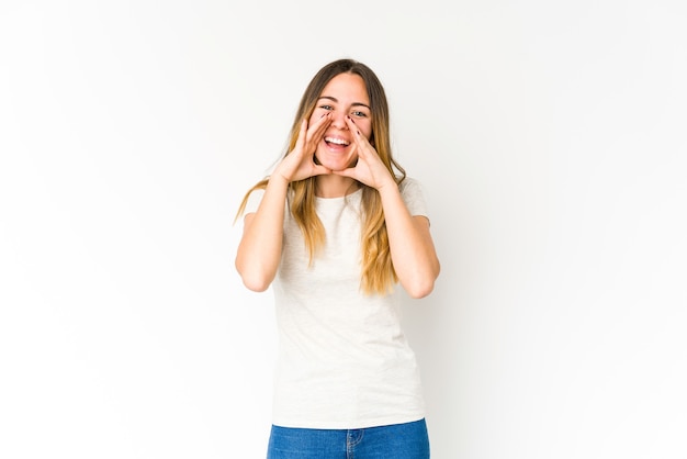 Jeune femme caucasienne sur blanc disant un potin, pointant vers le côté rapportant quelque chose.