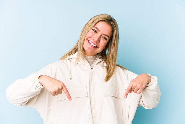 Jeune femme caucasienne blonde étreintes isolées, souriant insouciant et heureux.