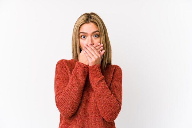 Jeune femme caucasienne blonde isolée choqué couvrant la bouche avec les mains.