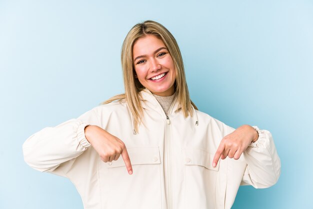 Jeune femme caucasienne blonde isolée debout avec la main tendue montrant le panneau d'arrêt, vous empêchant.