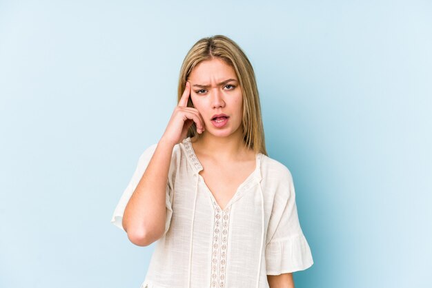 Jeune femme caucasienne blonde isolée montrant un geste de déception avec l'index.