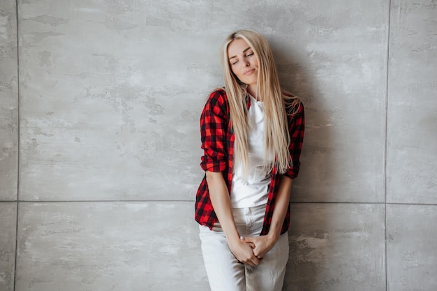 Jeune femme caucasienne blonde solitaire en chemise à carreaux debout à la maison dans la frustration s'appuie sur le mur de marbre regarde tristement vers le bas Une fille scandinave surchargée se sent fatiguée Erreur d'échec de la maquette