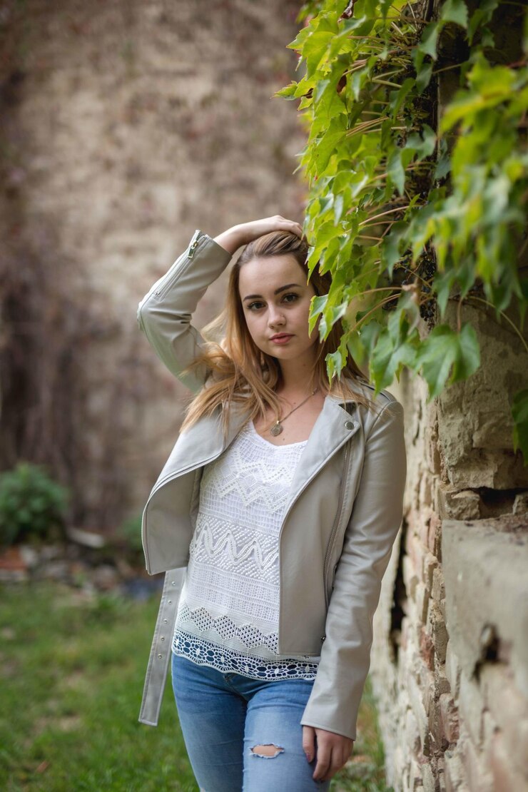Jeune femme caucasienne de Bosnie-Herzégovine portant une veste en cuir posant près des plantes