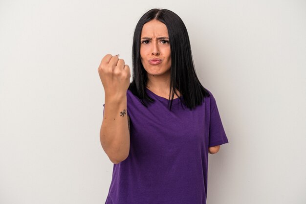 Jeune femme caucasienne avec un bras isolé sur fond blanc montrant le poing à la caméra, expression faciale agressive.