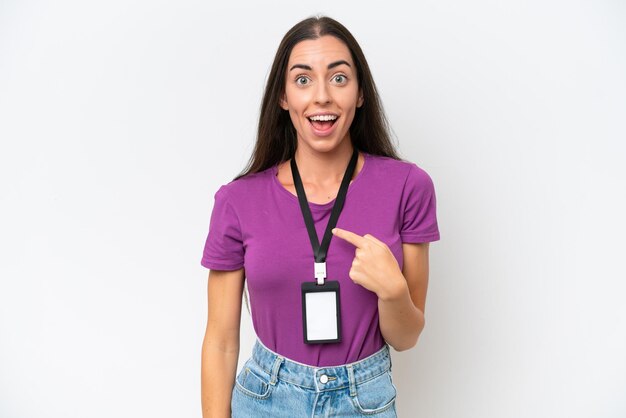 Jeune femme caucasienne avec carte d'identité isolée sur fond blanc avec une expression faciale surprise