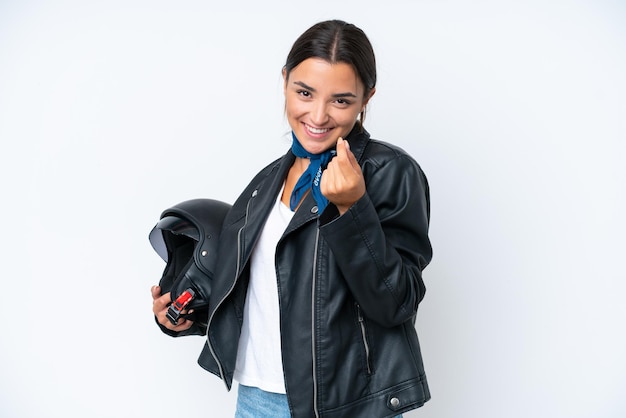 Jeune femme caucasienne avec un casque de moto isolé sur fond bleu faisant un geste d'argent