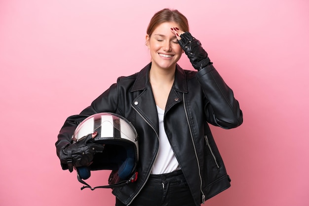 Une jeune femme caucasienne avec un casque de moto isolé sur fond rose a réalisé quelque chose et a l'intention de trouver la solution