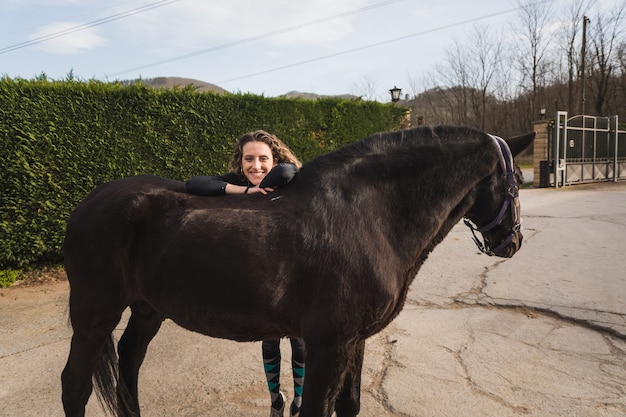 Jeune Femme Caucasienne Avec Un Cheval Dans Un Centre équestre